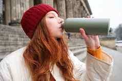 年轻的红色头发的人女旅游休息旅行打开热水瓶饮料热茶打破观光