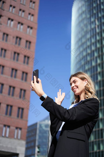 肖像微笑<strong>企业</strong>女人<strong>视频</strong>调用街持有移动电话挥舞着智能手机相机穿西装