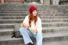 年轻的红色头发的人女旅游休息旅行打开热水瓶饮料热茶打破观光