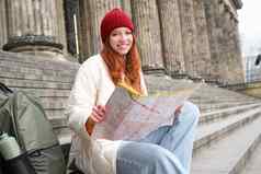 旅游生活方式概念年轻的红色头发的人女人城市地图计划路线观光一天坐在在户外楼梯休息