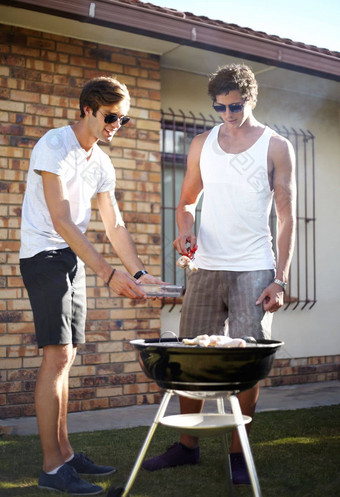 烧烤完美年轻的人烧烤肉烧烤在户外生活方式