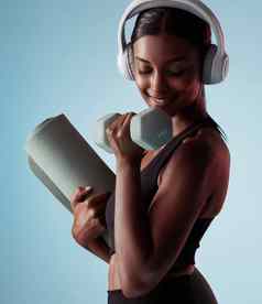 瑜伽哑铃女人工作室培训强大的肱二头肌锻炼耳机音乐流媒体健身健康的快乐女孩听音频广播提升权重手臂权力
