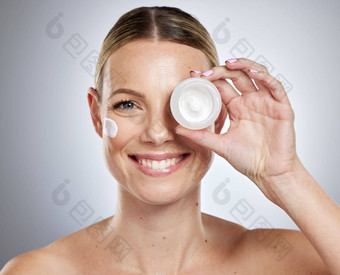 脸<strong>护肤品</strong>产品模型女人持有美容器工作室灰色的背景肖像面部化妆品有吸引力的年轻的女持有保湿霜乳液