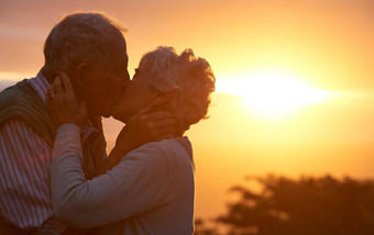 宝时刻上了年纪的夫妇分享浪漫的时刻日落