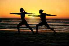 夫妇轮廓海滩瑜伽日落健康健身健康战士构成Zen脉轮男人。女人伸展运动培训练习普拉提平衡在户外海滨