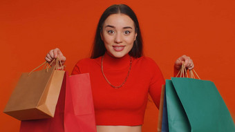 年轻的女人显示购物袋广告折扣惊讶低价格假期