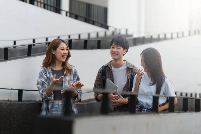 美丽的年轻的亚洲女人大学学生朋友在户外大