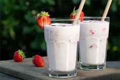 草莓奶昔玻璃眼镜新鲜的草莓木表格院子里