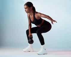 黑色的女人壶铃锻炼健康焦点动机健康健身工作室背景女教练培训运动员健康的锻炼强大的运动服装