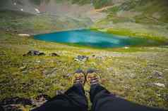 旅行者休息山高原第一人称视图特写镜头腿背景山绿松石湖