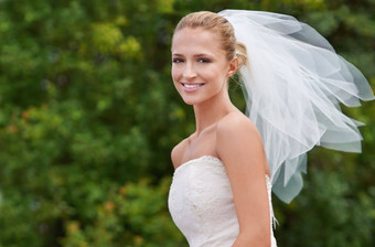 惊人的大一天华丽的年轻的新娘微笑惊人的婚礼衣服与Copyspace