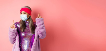 科维德社会距离时尚概念快乐的亚洲高级女人喜欢聚会，派对跳舞呼吸器闪亮的紫色的衣服站粉红色的背景