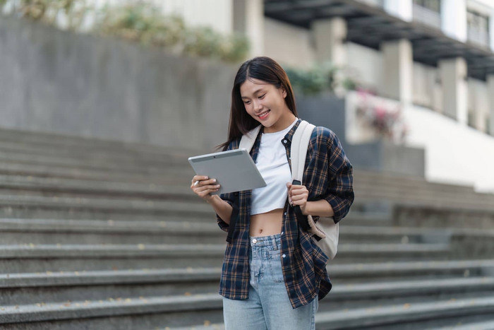 美丽的年轻的亚洲女人大学学生朋友在户外大