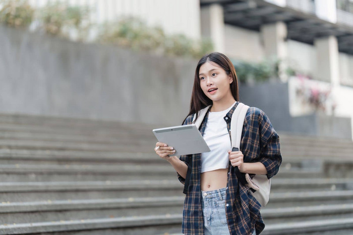 美丽的年轻的亚洲女人大学学生朋友在户外大