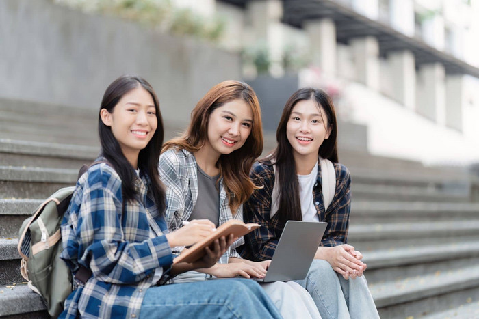 美丽的年轻的亚洲女人大学学生朋友在户外大