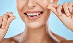 女人牙线牙齿变焦微笑牙科医疗保健新鲜的呼吸口清洁孤立的蓝色的背景脸手快乐口服卫生产品健康的牙龈用牙线清洁牙齿工作室
