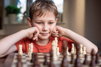 年轻的白色孩子玩游戏国际象棋大国际象棋董事会国际象棋董事会表格前面学校男孩思考移动