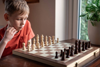 年轻的白色孩子玩游戏国际象棋大国际象棋董事会国际象棋董事会<strong>表格</strong>前面学校男孩思考移动