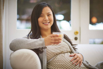 放纵欲望激素编造肖像有吸引力的年轻的怀孕了女人喝冰咖啡放松沙发首页