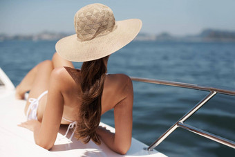 度假奢侈品有吸引力的年轻的女人晒黑甲板奢侈品游艇