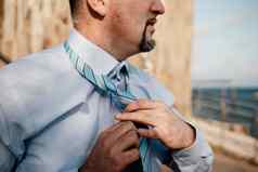 关闭男人。调整领带西装商人蓝色的衬衫整理了一下领带特写镜头
