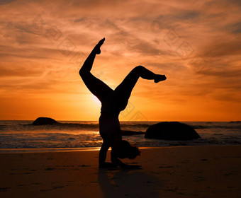 瑜伽轮廓倒立构成日落海滩海洋海晚上锻炼放松锻炼培训瑜珈女人沙子平衡日出医疗保健健康健身强大的身体