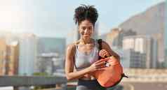 黑色的女人健身房袋城市健身锻炼强大的锻炼在户外肖像年轻的非洲运动员持有行李培训体育健康的生活方式城市背景