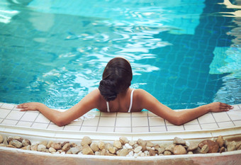 姥幸福舒缓的水域后视镜拍摄年轻的女人放松室内池美水疗中心