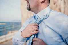 关闭男人。调整领带西装商人蓝色的衬衫整理了一下领带特写镜头