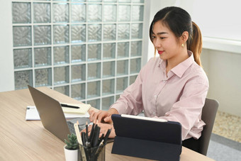 微笑年轻的女金融顾问沟通客户<strong>端移动</strong>PC电脑办公室桌子上