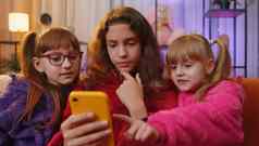 兄弟姐妹孩子们女孩智能手机发短信消息社会媒体应用程序在线