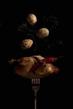 鹌鹑叉鸡蛋炸鹌鹑叉特写镜头黑色的背景谢尔胡鹌鹑鸡蛋飞翼红色的热胡椒豆荚垂直照片