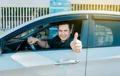 满意司机男人。显示拇指年轻的司机男人。车显示拇指快乐司机给拇指路安全开车概念