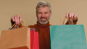 中年男人。显示购物袋广告折扣微笑惊讶低价格