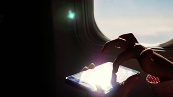 特写镜头太阳的射线反映了电话黑暗轮廓孩子手移动电话飞机的照明器孩子戏剧游戏智能手机平板电脑电话飞机小屋