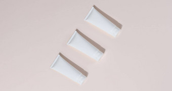白色塑料管子化妆品米色背景前视图模板品牌