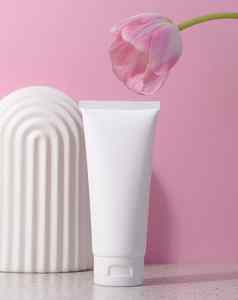 白色塑料管化妆品产品粉红色的背景拱粉红色的郁金香广告品牌产品