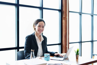 肖像年轻的亚洲女人显示微笑脸电脑金融语句