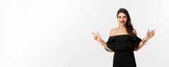 时尚美有吸引力的女人珠宝化妆黑色的衣服笑指出手指横盘整理复制空间提供白色背景