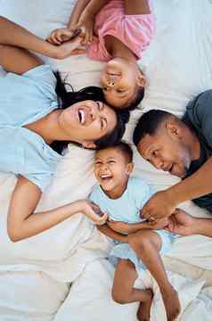 快乐有趣的家庭卧室床上妈妈。父亲孩子们笑早....首页有趣的时间爱父母护理孩子们逗玩幸福成键