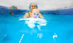 可爱的婴儿女孩享受游泳池妈妈。早期发展类婴儿教学孩子们游泳潜水