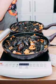 烹饪黑色的意大利面海鲜烹饪类意大利意大利面海鲜贻贝鱿鱼虾自制的食物