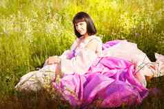 美丽的女孩郁郁葱葱的粉红色的球礼服绿色场盛开的花蓝色的天空背景模型摆姿势自然景观公主法雷演讲