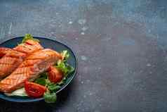烤鱼大马哈鱼牛排蔬菜沙拉陶瓷板乡村石头背景角视图平衡饮食健康的营养沙拉餐大马哈鱼蔬菜空间文本
