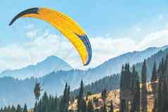 黄色的滑翔伞滑翔伞空气背景风景如画的山