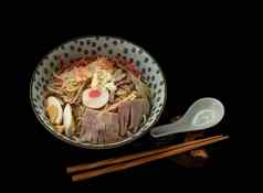 冷面条remen烤猪肉切片虾他煮熟的蛋柠檬酱汁蓝色的陶瓷碗服务勺子筷子