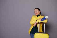 时尚的女乘客旅行在国外假期等待董事会飞行站黄色的手提箱