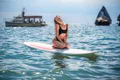 女人肉豆蔻海体育女孩冲浪板海阳光明媚的夏天一天黑色的洗澡西装坐在萨帕海休息海