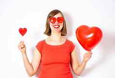 美丽的微笑女人红色的太阳镜持有手心气球心棒棒糖