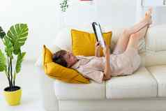 女人穿睡衣读取杂志沙发生活房间家居服睡衣裤购物出售